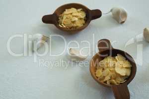 Spices in bowl with garlic on white background