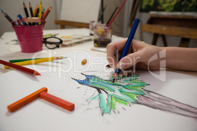 Close-up of woman sketching in drawing book