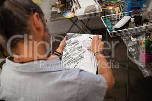 Man sketching in drawing book