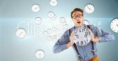 Surprised business man holding a clock against background with clocks