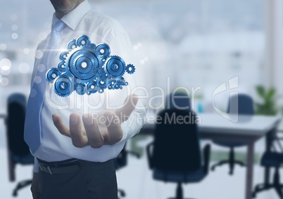 Businessman with Open hand with cog gears in office