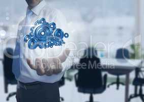 Businessman with Open hand with cog gears in office