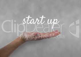 Hand interacting with start-up business text against grey background