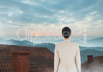 Businesswoman standing on Roofs with chimney and misty colorful landscape