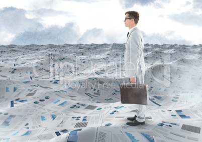 Businessman holding briefcase in sea of documents under sky clouds