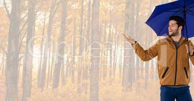 Man in Autumn with umbrella in bright forest