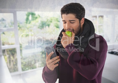 Man in Autumn with apple and phone at home