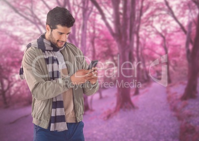 Man in Autumn with phone in forest
