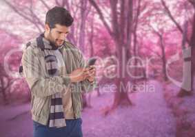 Man in Autumn with phone in forest