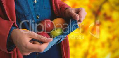 Composite image of mid section of woman carrying fruits in shirt