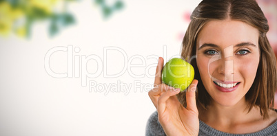 Composite image of portrait of woman holding granny smith apple