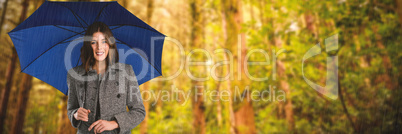 Composite image of portrait of young woman holding umbrella