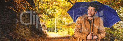 Composite image of man standing with blue umbrella