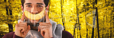 Composite image of close-up portrait of man holding banana