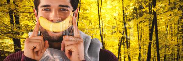 Composite image of close-up portrait of man holding banana