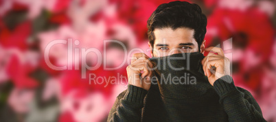 Composite image of portrait of man hiding face with sweater