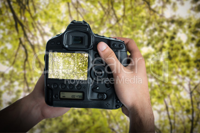 Composite image of cropped image of hands holding camera