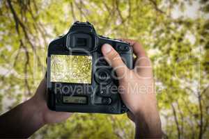 Composite image of cropped image of hands holding camera