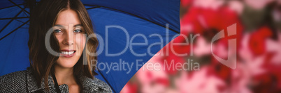Composite image of close up portrait of woman with blue umbrella