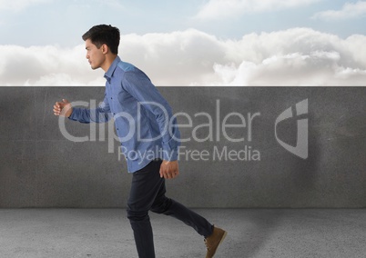 Businessman full body_Businessman running by stone wall and clouds