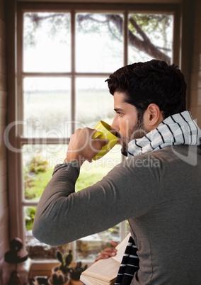 Man in Autumn with cup by window at home