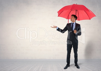 Businessman under umbrella in room