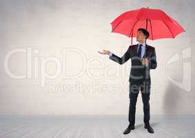 Businessman under umbrella in room
