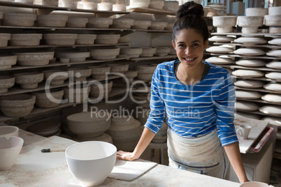 Female potter smiling in pottery workshop