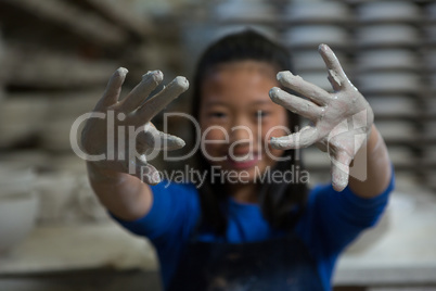 Happy girl showing muddy hands