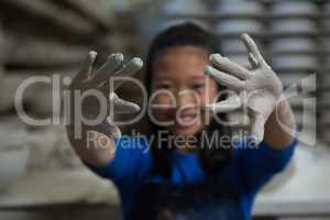 Happy girl showing muddy hands