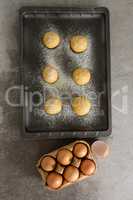 Dough balls with icing sugar on baking tray