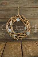Christmas wreath hanging on wooden plank