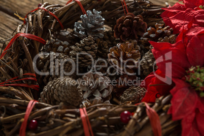 Close up of artificial nest with pine cones and poinsettia flowers