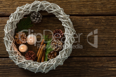 Overhead view of pine cones with illuminated candles and wreath