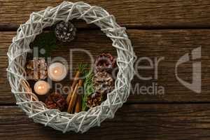 Overhead view of pine cones with illuminated candles and wreath