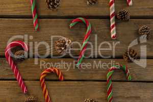 Overhead view of candy canes and pine cones on table