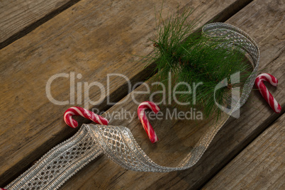 Candy canes with twigs and ribbon on table