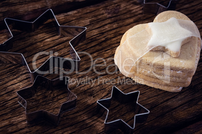Cookie cutter and cookie on wooden plank
