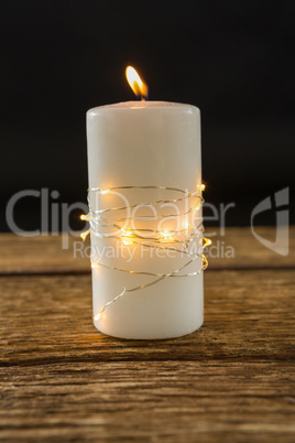 Close up of illuminated string lights wrapped on lit candle