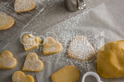 Raw heart shape cookies with sugar icing on wax paper