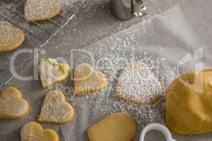 Raw heart shape cookies with sugar icing on wax paper