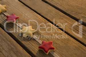High angle view of star shaped cookies arranged on ribbon at table