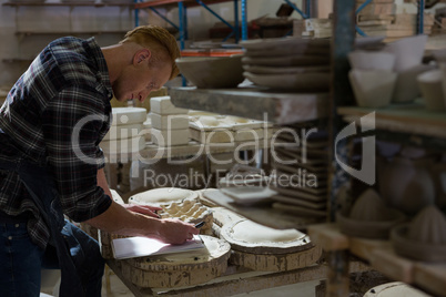 Male potter writing on a clipboard