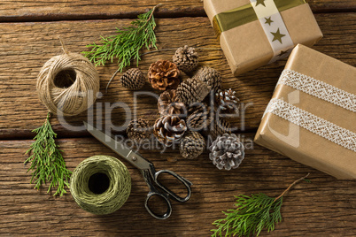 Overhead view of pine cones with gift boxes and thread spools