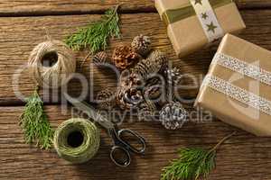 Overhead view of pine cones with gift boxes and thread spools