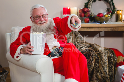 Santa Claus holding television remote control