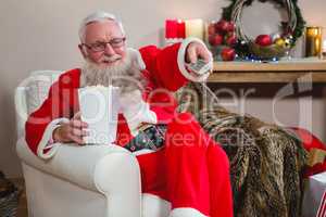 Santa Claus holding television remote control