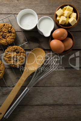 Fresh baked cookies, whisk, eggs, flour on wooden table