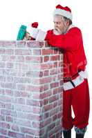 Santa claus placing gift box into a chimney