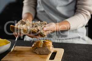 Woman cutting open a brown bun